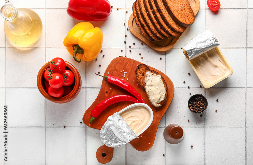 Wooden board with boxes of processed cheese, bread and vegetables on white tile background