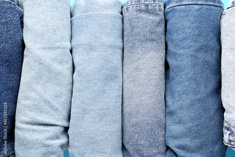 Different folded jeans as background, closeup