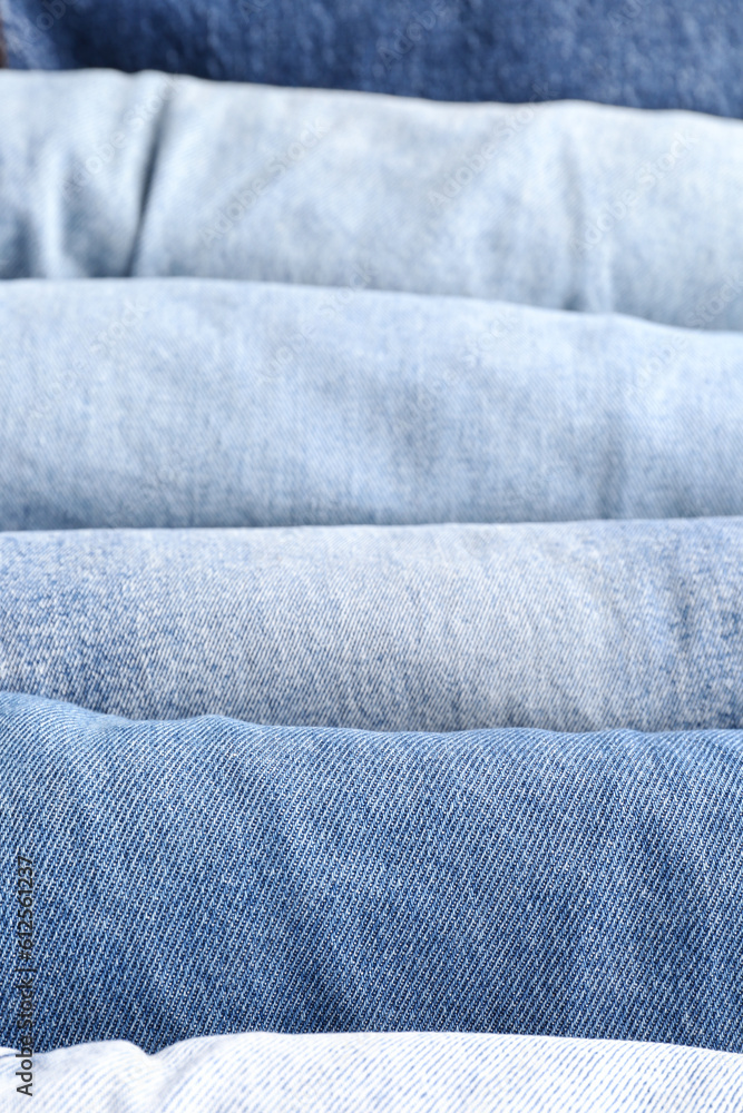 Different folded jeans as background, closeup