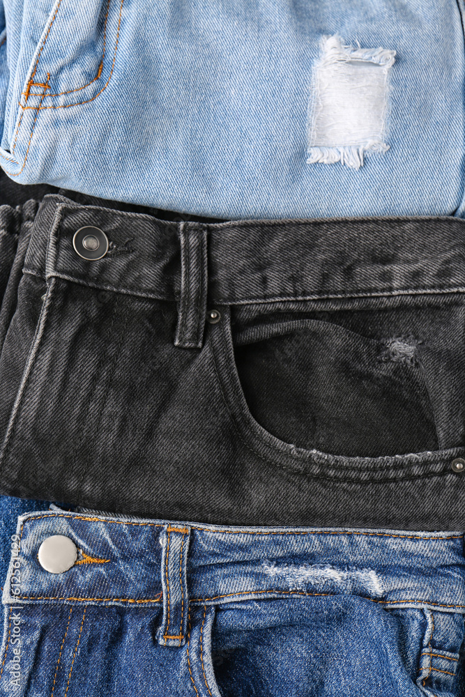 Different folded jeans as background, closeup