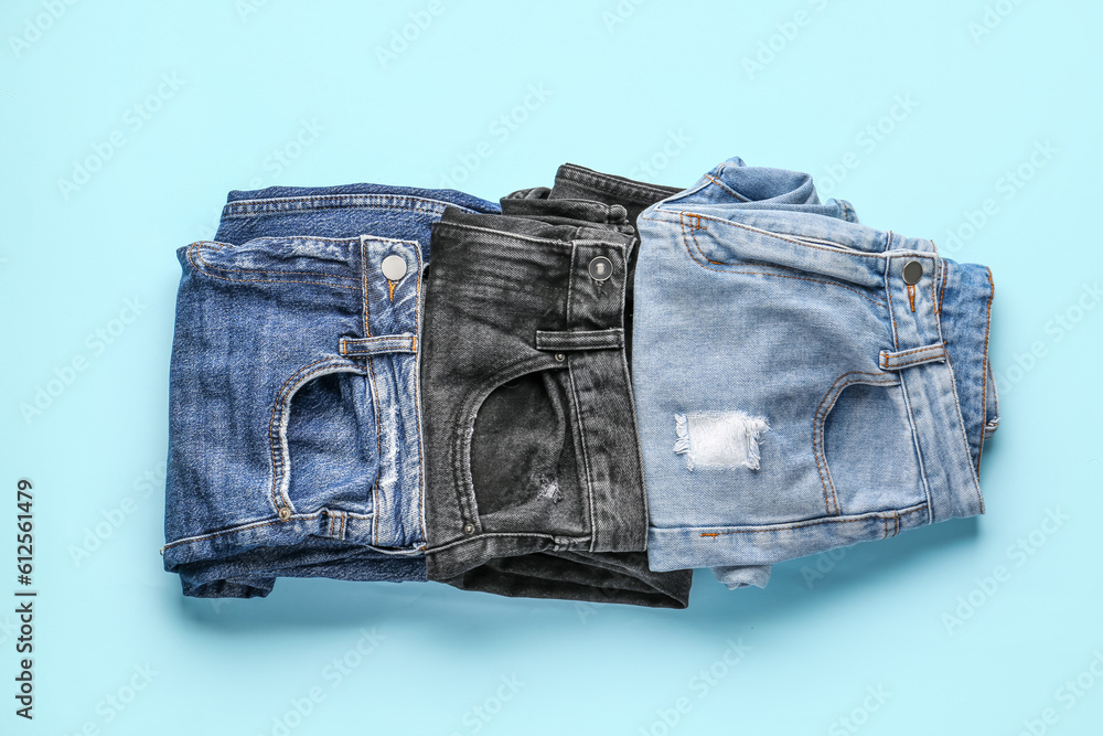 Different folded jeans on blue background