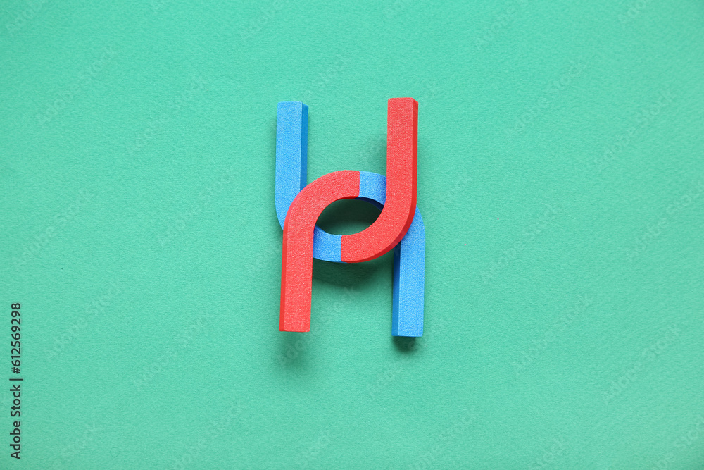 Horseshoe shaped magnets on green background