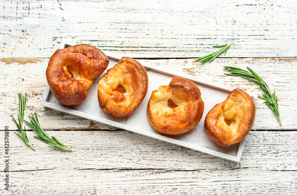 Plate with tasty Yorkshire pudding on light wooden background