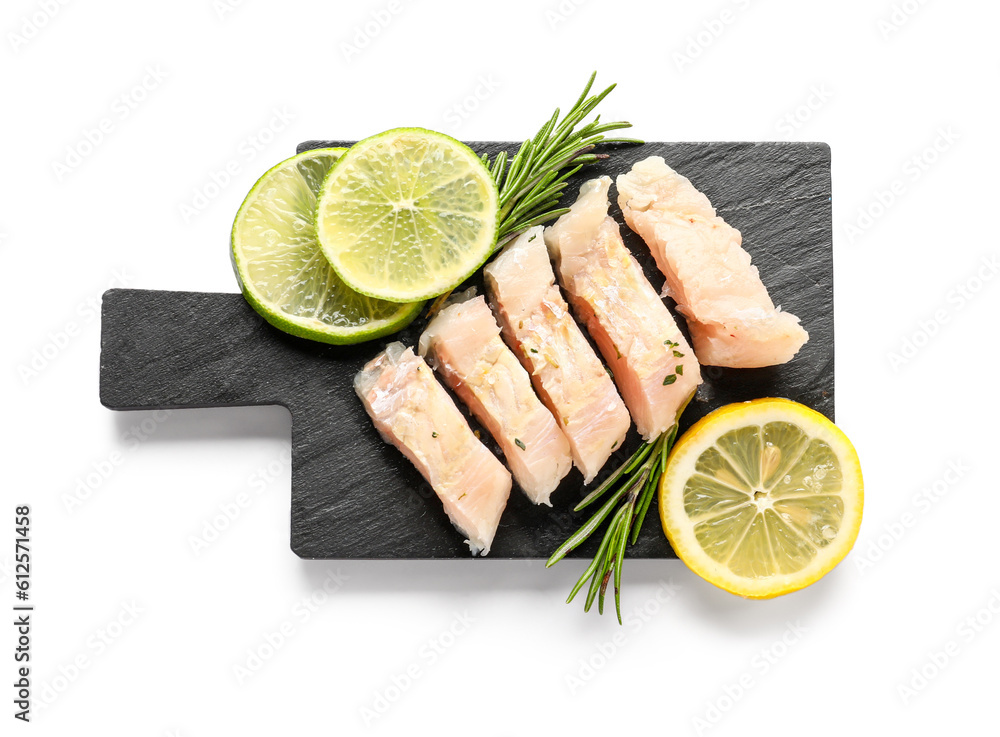 Slate board with pieces of codfish fillet on white background