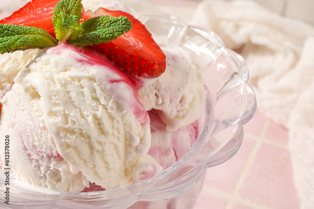 Bowl of vanilla ice cream with strawberries and mint on pink tile table, closeup