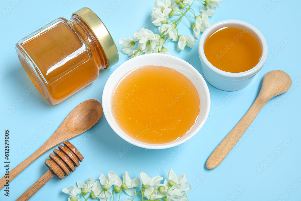 Composition with sweet honey and acacia flowers on blue background, closeup