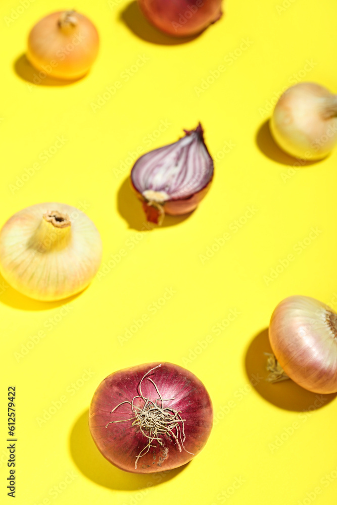 Different kinds of onion on yellow background, closeup