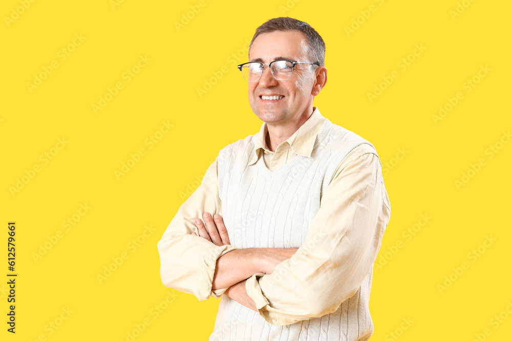 Mature man in eyeglasses on yellow background