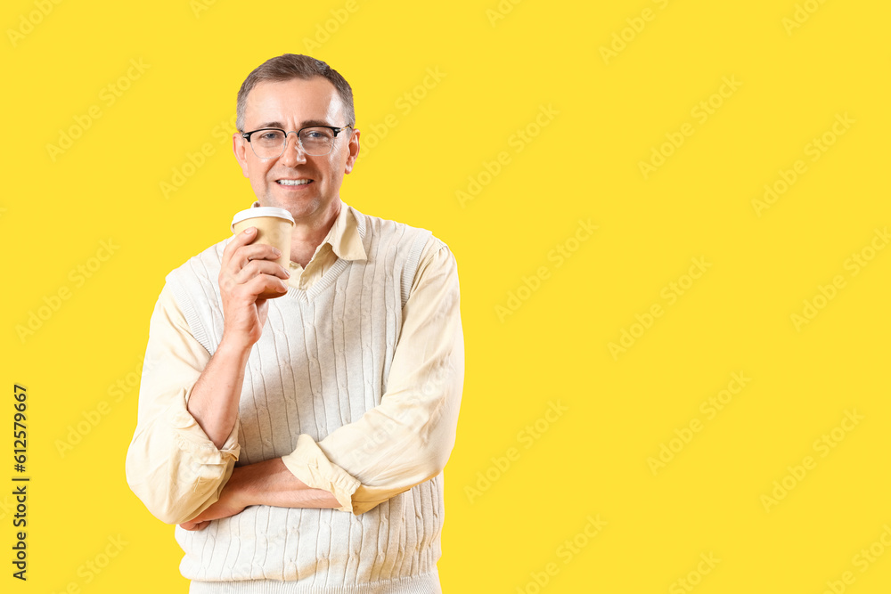 Mature man in eyeglasses on yellow background