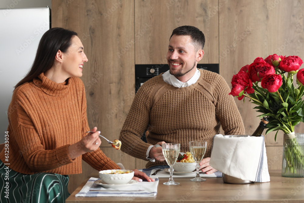 Happy engaged couple having dinner in kitchen