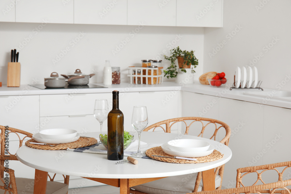 Served dining table in interior of light kitchen