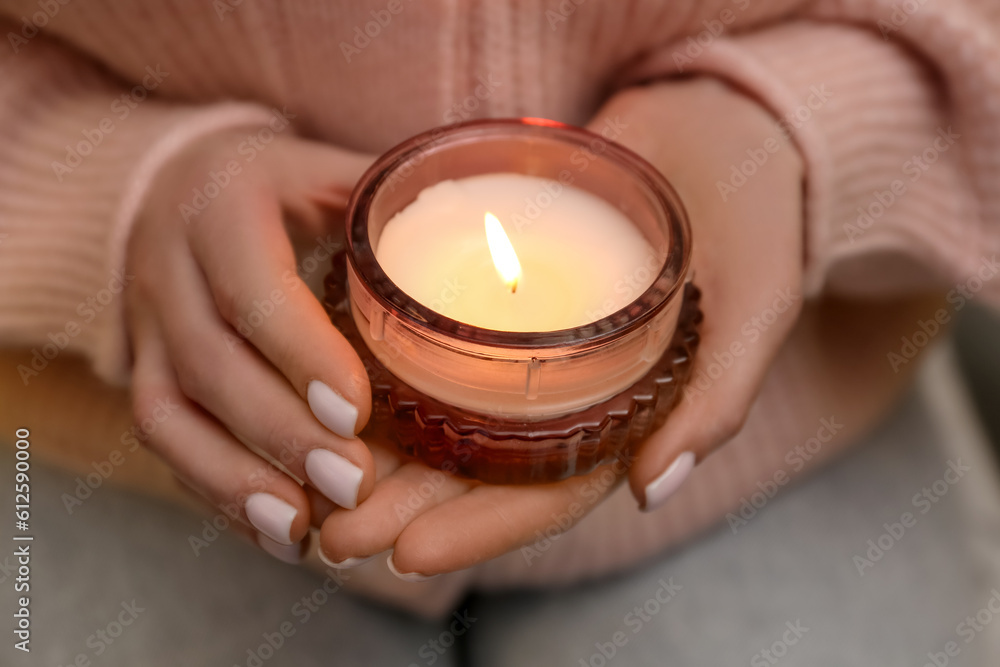 Woman with beautiful burning candle, closeup