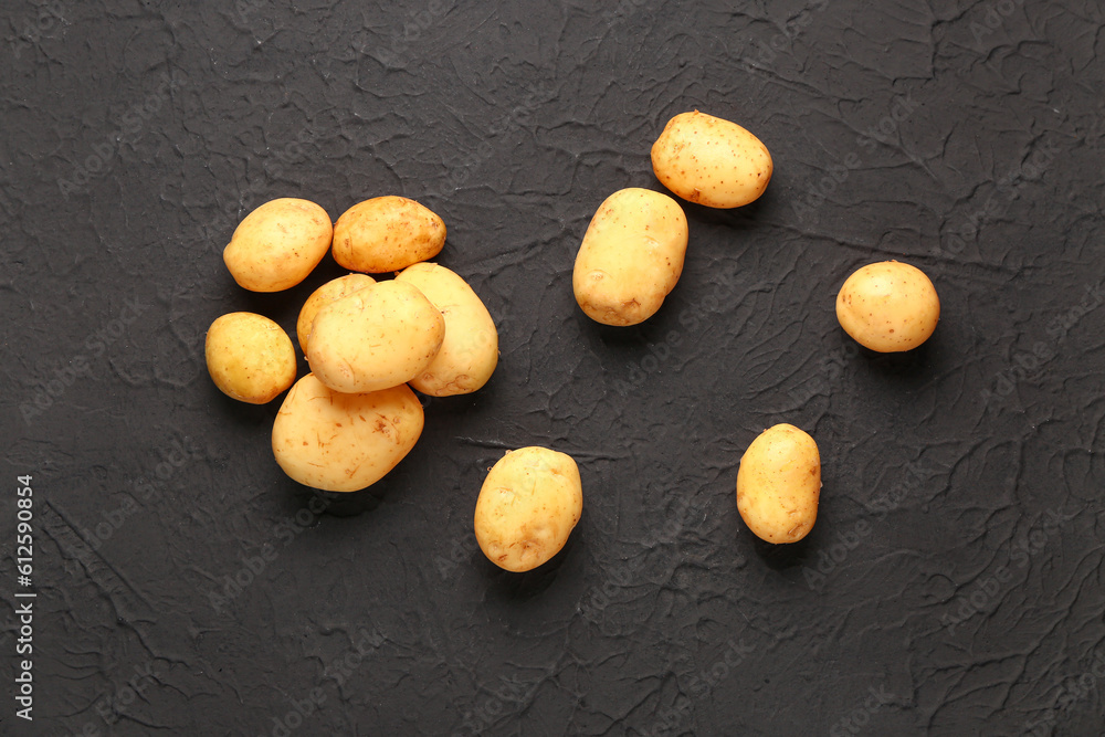 Raw baby potatoes on black background