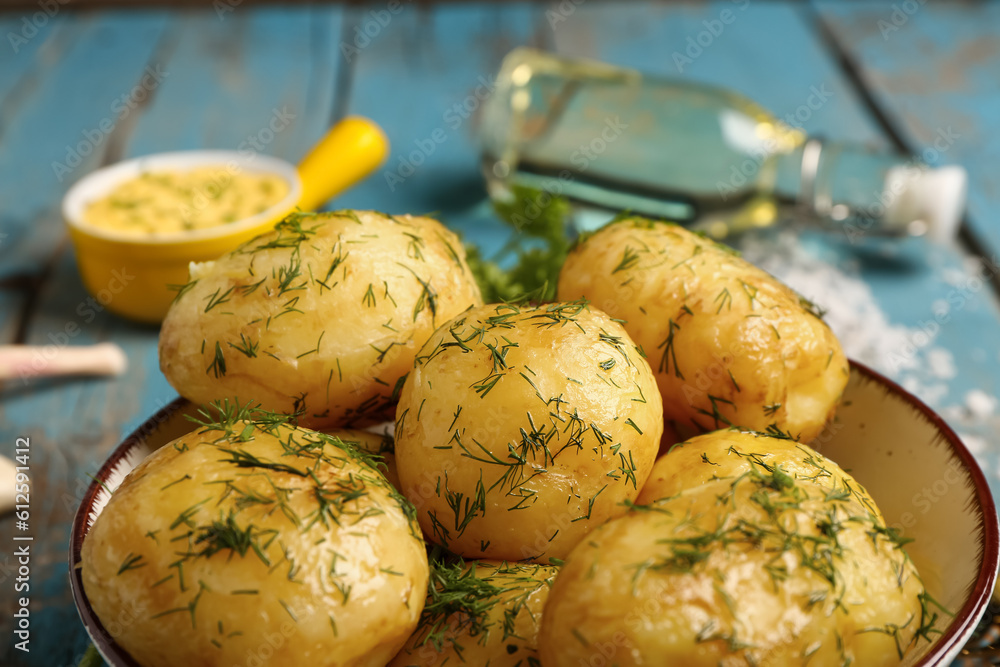 Plate of boiled baby potatoes with dill on blue wooden background