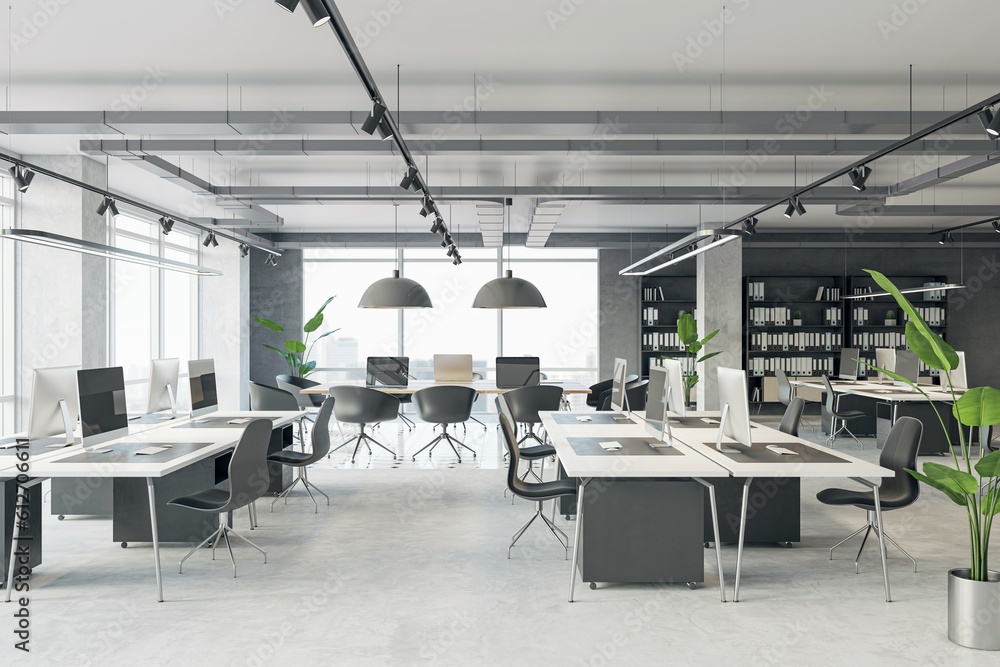 Comfortable workplaces in a modern open loft office interior with desks, computers, and a window. Co