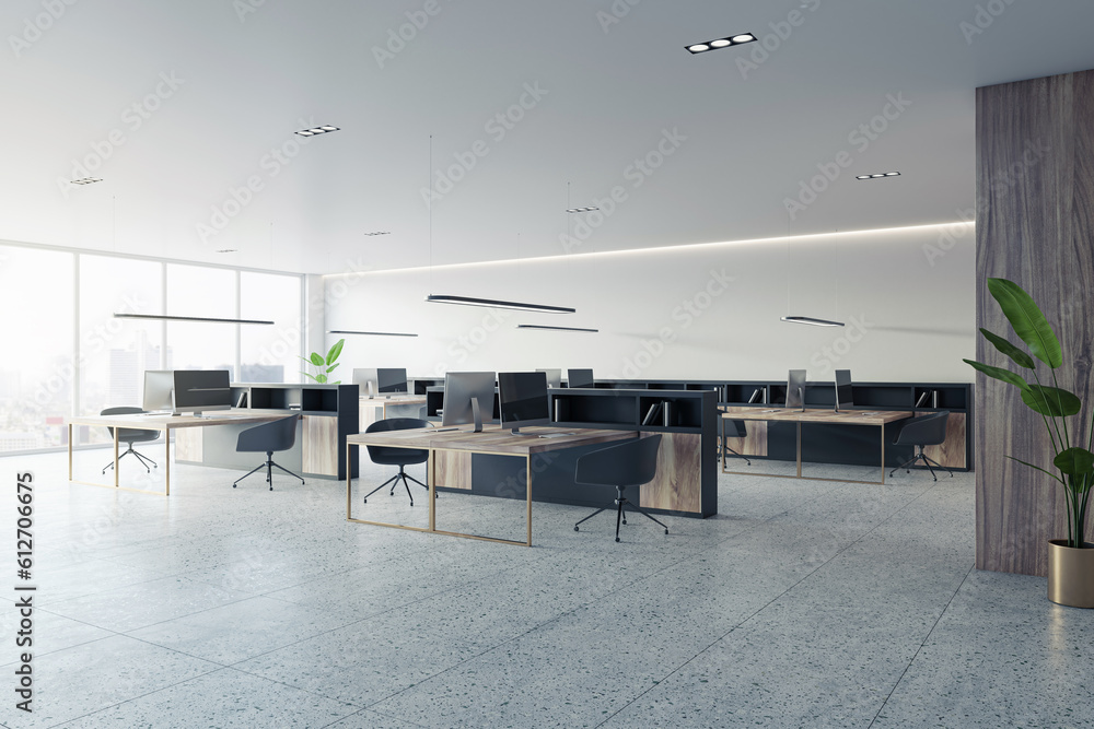 Open office interior layout with desks, computers, and a window. The concrete floor and white walls 