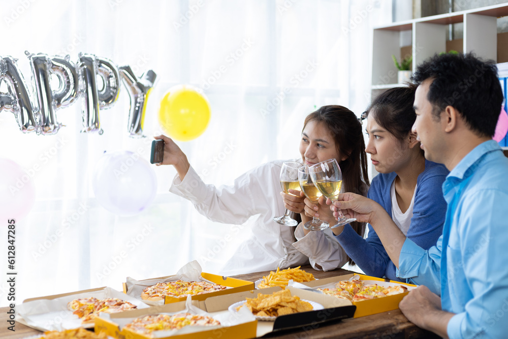 Let the party begin! Group of young people having fun together with champagne and pizza. Celebrating