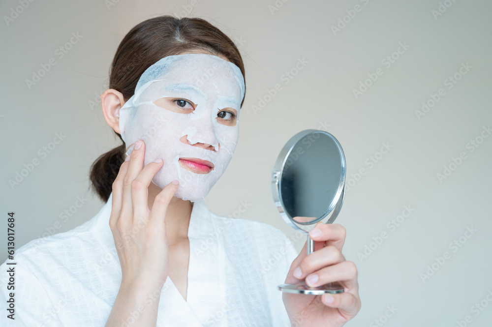 Portrait of young woman applying facial mask for enhance her skin. Facial mask is a creamy or thick 