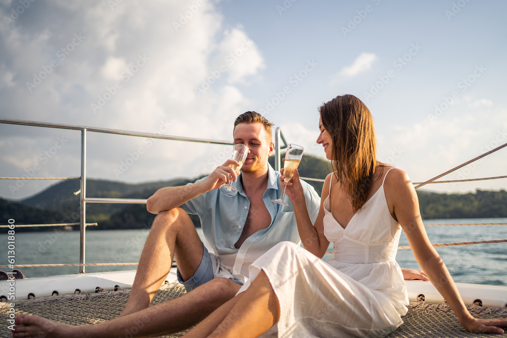 Caucasian young couple drinking champagne while having party in yacht. 