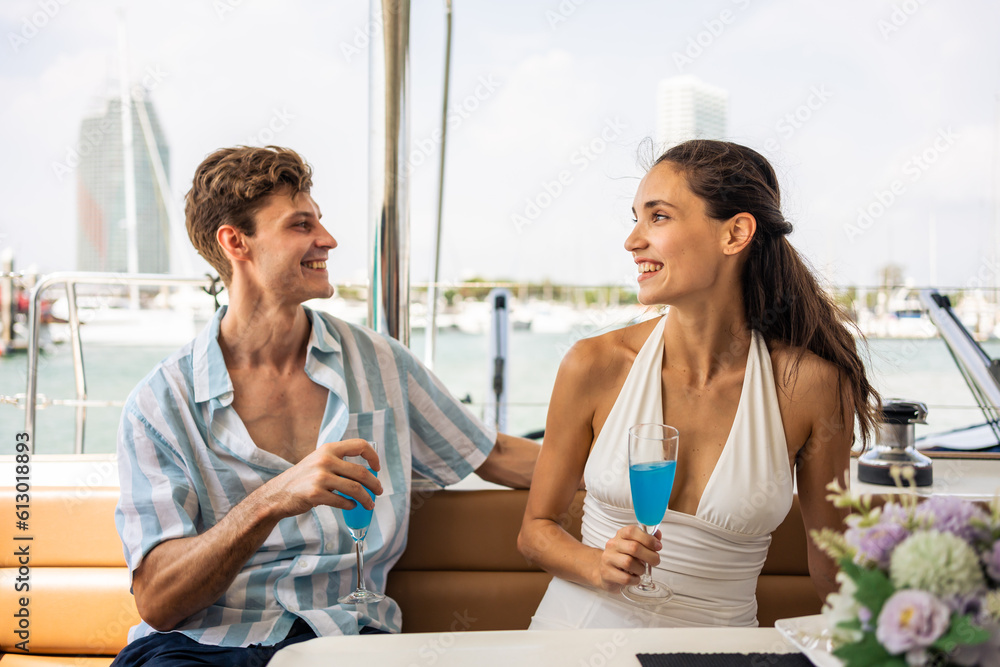 Caucasian young couple drinking champagne while having party in yacht. 