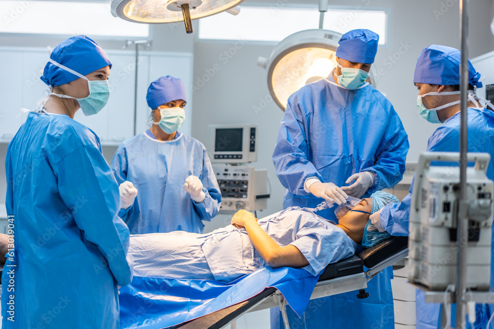 Professional doctors performing surgical operation in operating room.