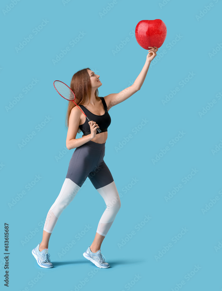 Sporty female badminton player on color background