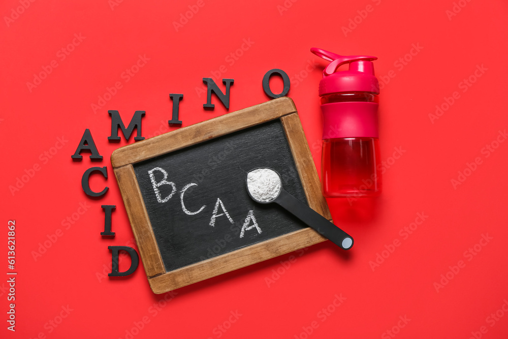 Chalkboard with letters BCAA, text AMINO ACID, powder and bottle of water on red background