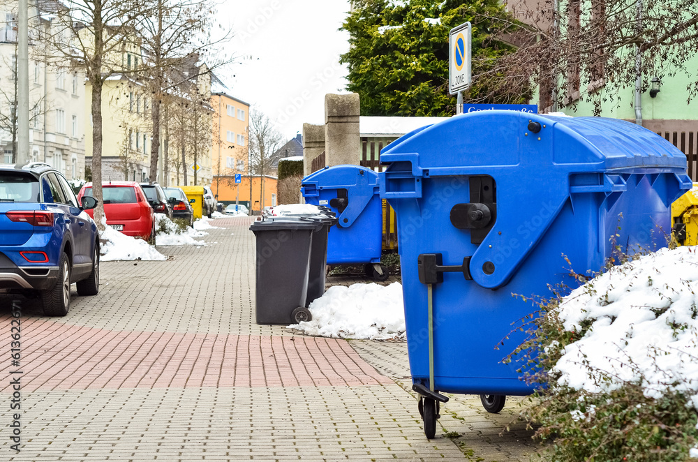 View of garbage containers in city on winter day