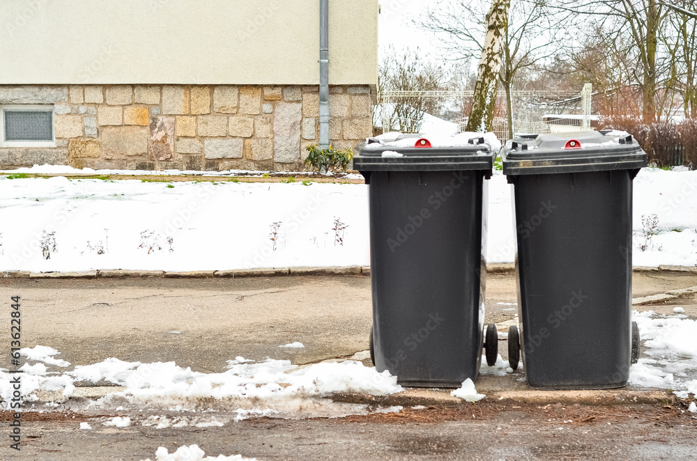 View of garbage containers in city on winter day