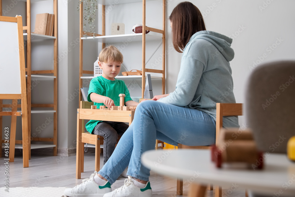 Little boy and nanny playing with cubes at home