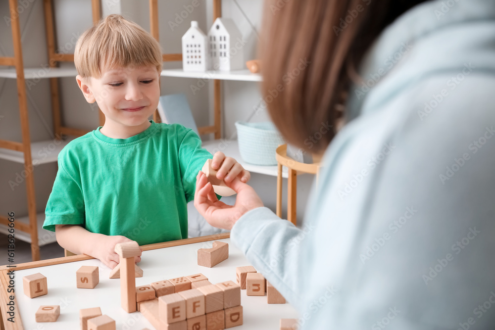 Little boy and nanny playing with cubes at home