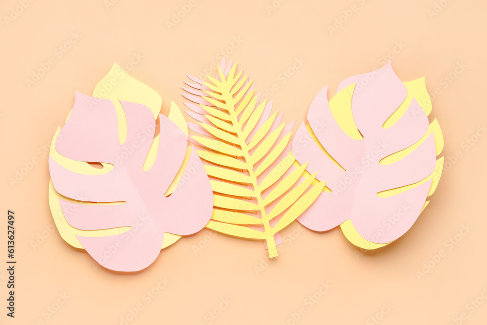 Paper tropical leaves on orange background