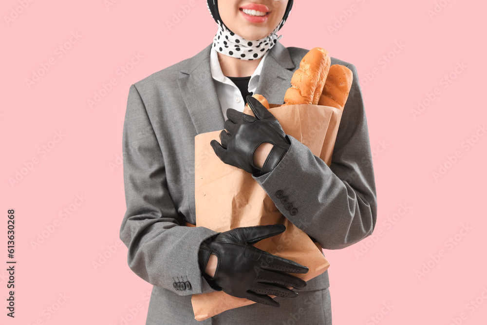 Stylish young woman in leather gloves with baguettes on pink background, closeup