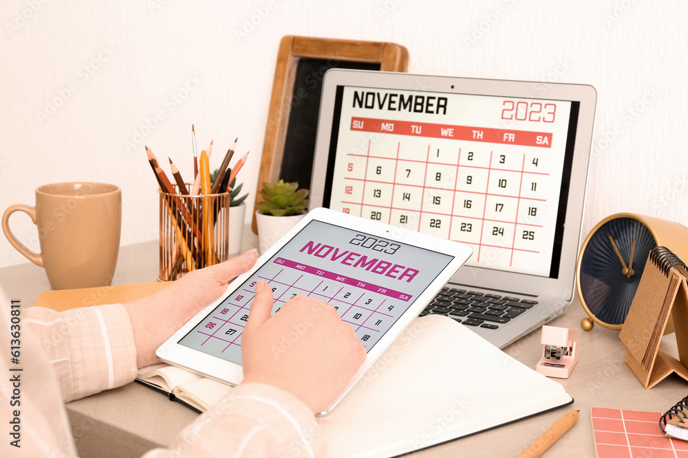 Woman holding tablet computer with calendar at workplace