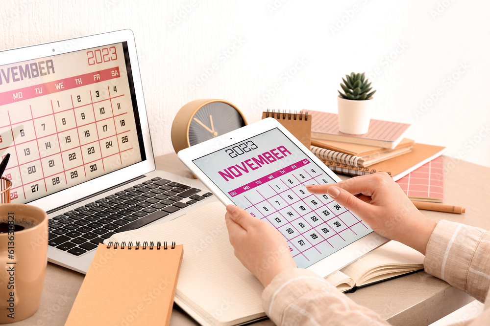 Woman holding tablet computer with calendar at workplace