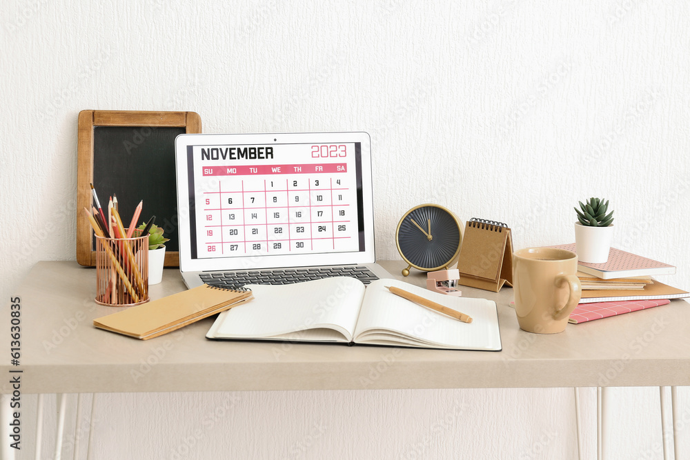 Modern laptop with calendar at workplace