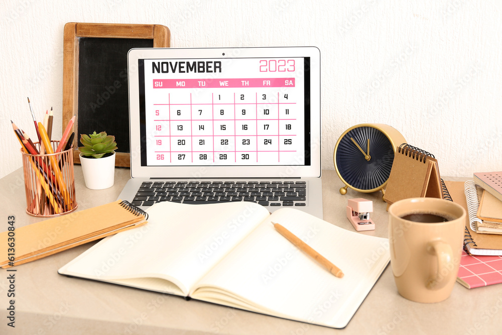 Modern laptop with calendar at workplace