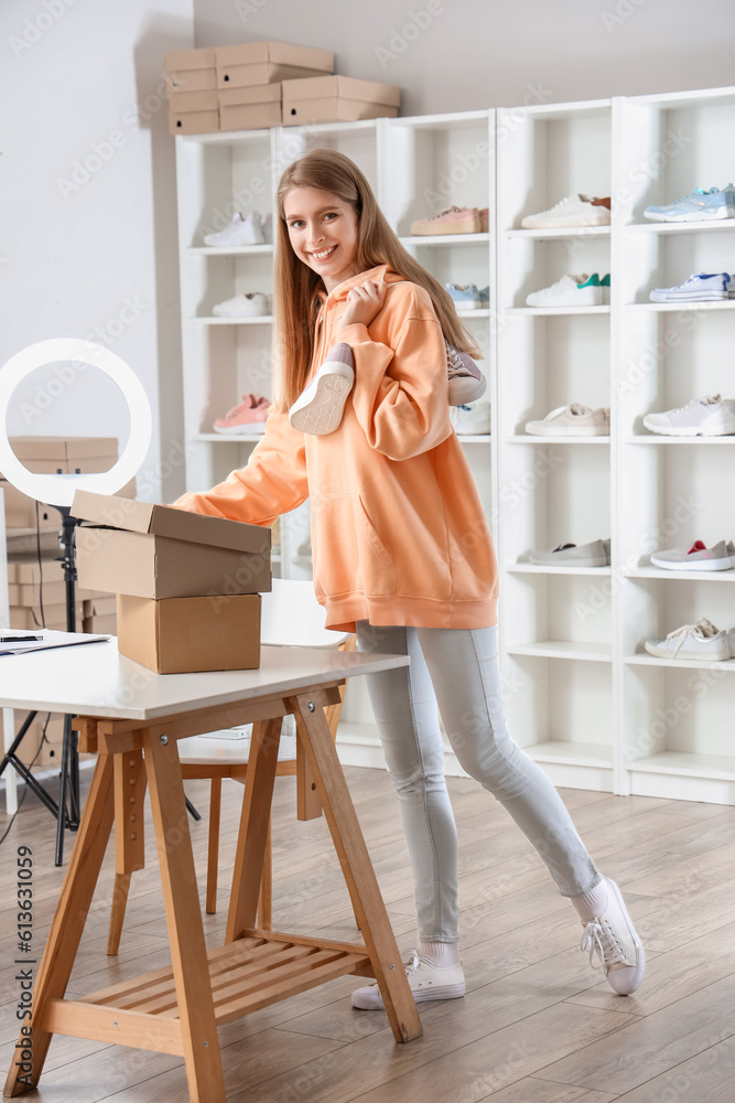 Female seller with sneakers in shoe shop