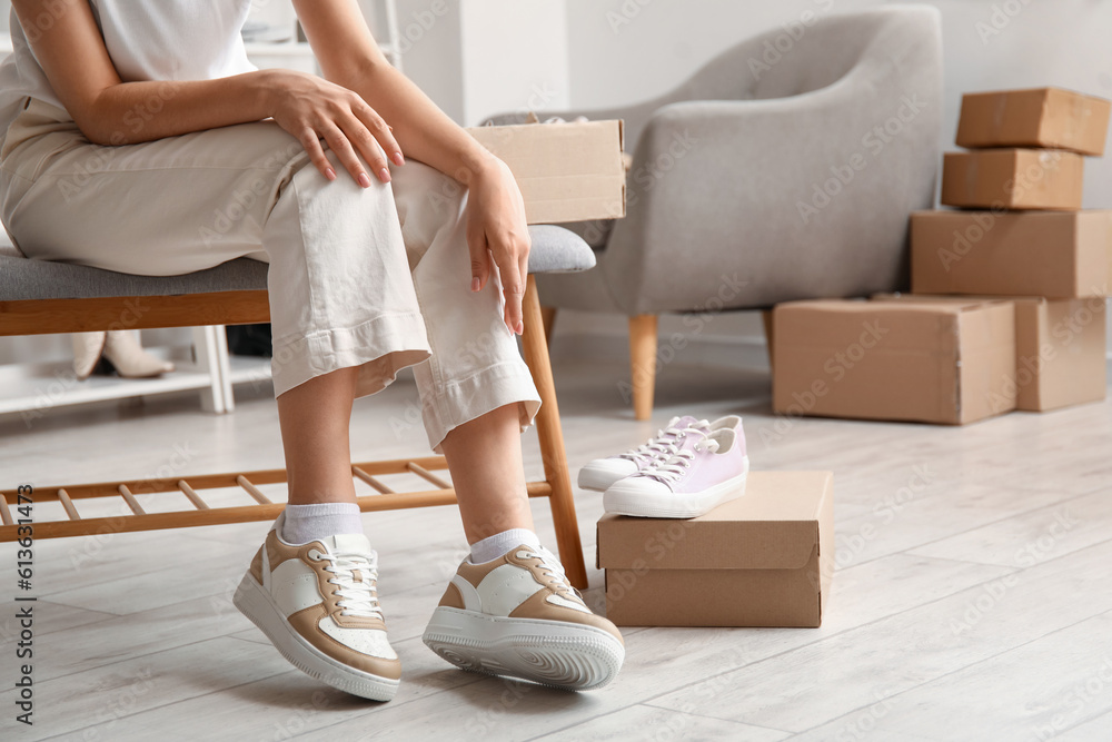 Woman trying on stylish sneakers in boutique