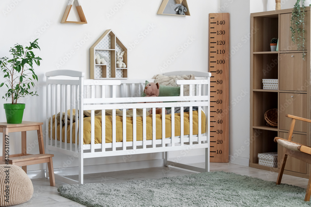 Interior of childrens bedroom with crib, shelves and toys