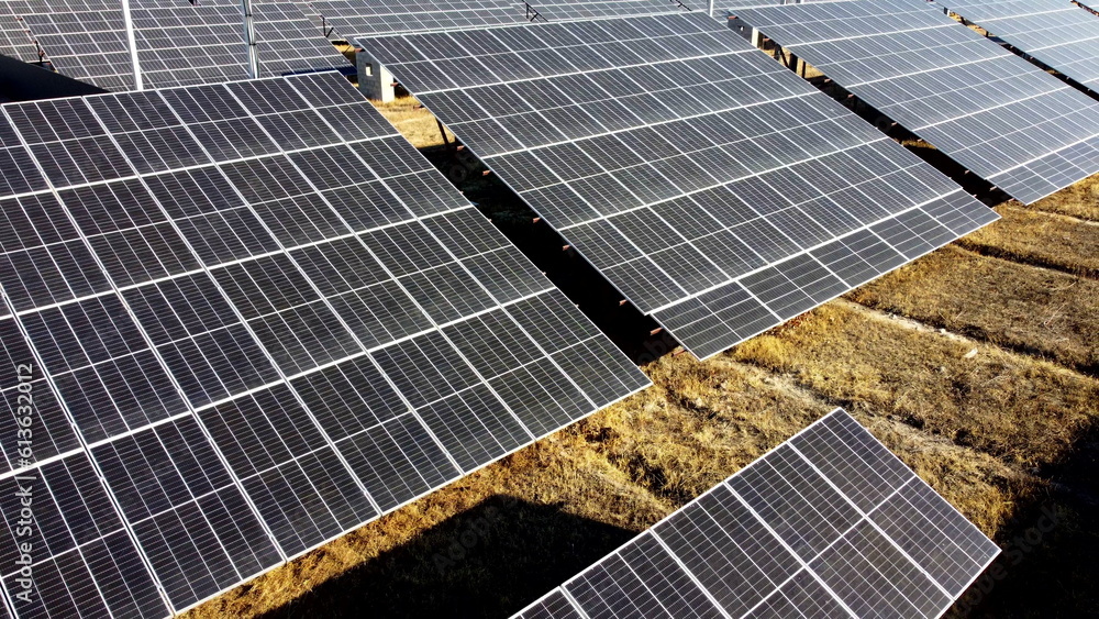 Solar power plant. Flight over modules of solar power station on sunny day. Renewable electrical ene