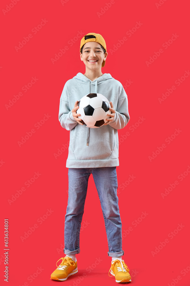 Little boy with soccer ball on red background