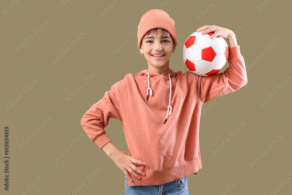 Little boy with soccer ball on color background