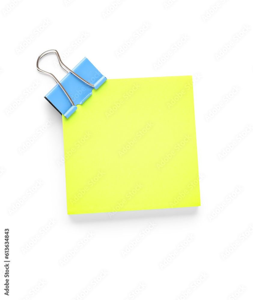 Yellow sticky note with paperclip on white background