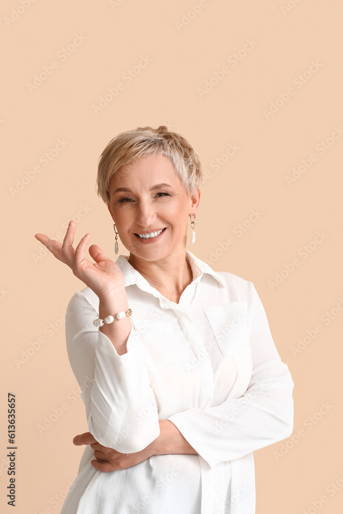 Mature blonde woman in white shirt on beige background