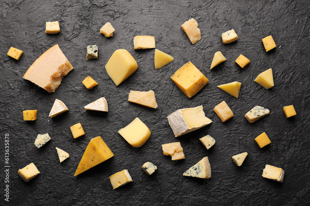 Pieces of tasty cheese on dark background