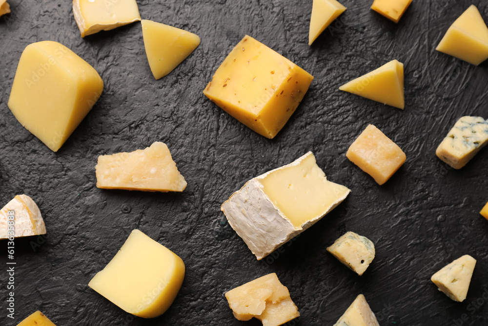 Pieces of tasty cheese on dark background