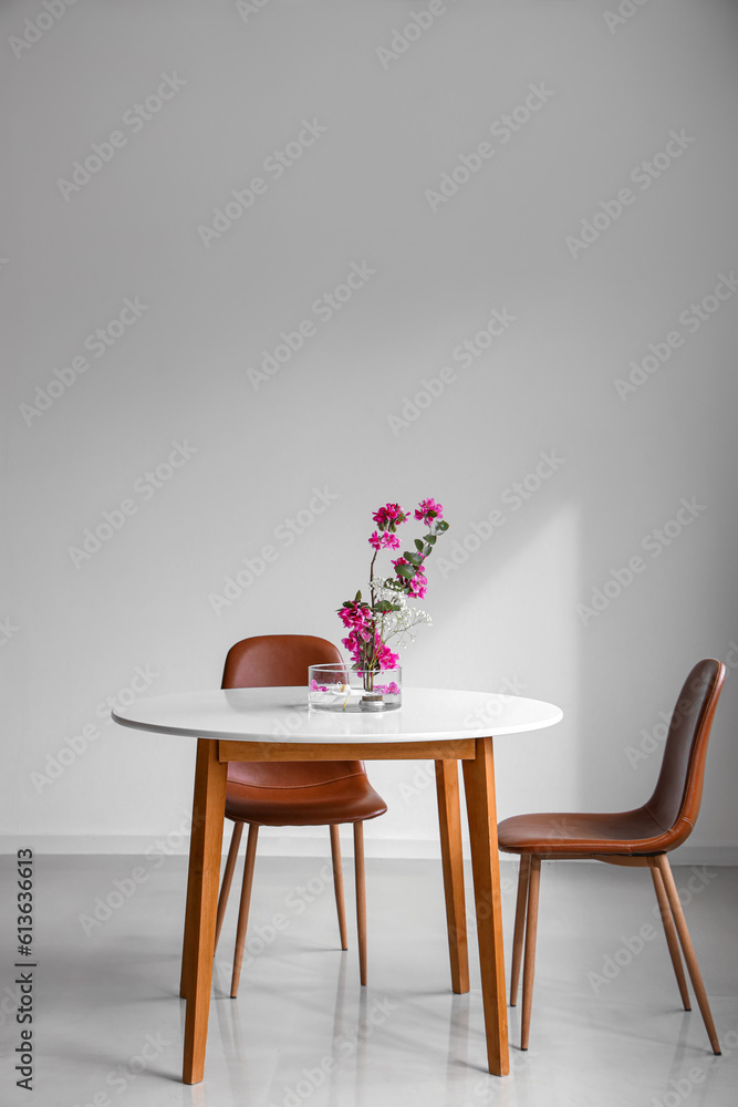 Beautiful ikebana on dining table in light room