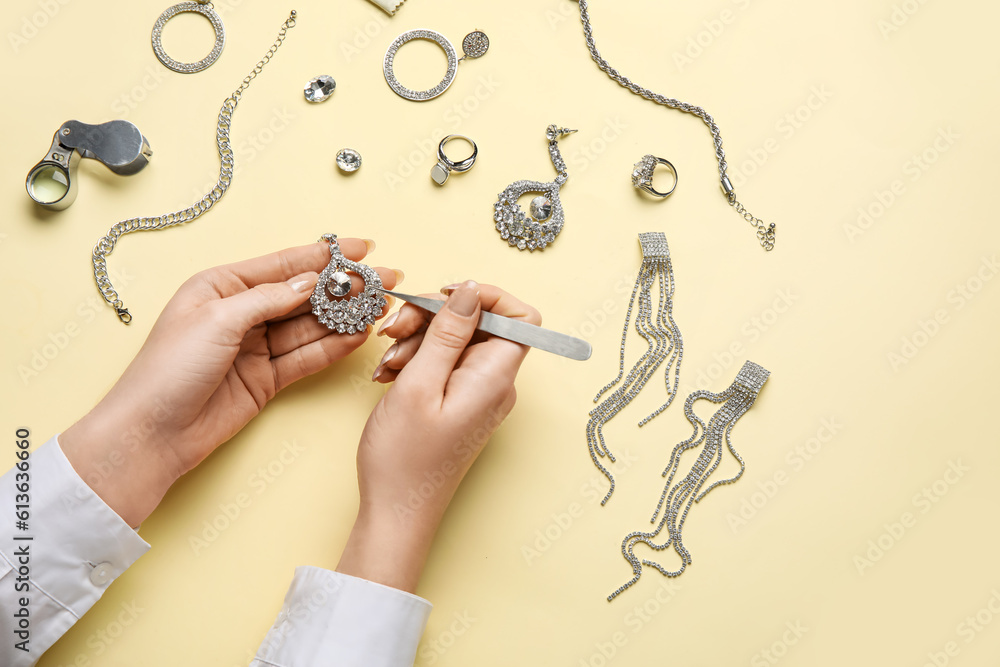 Woman cleaning stylish accessories on color background