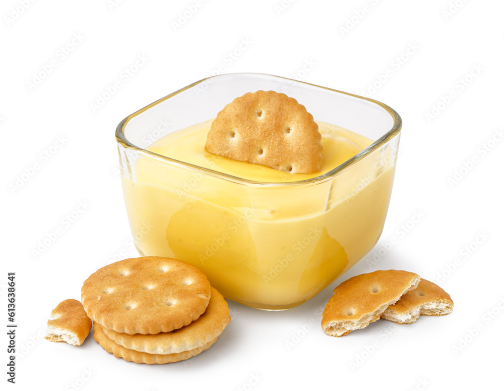 Bowl of tasty cheddar cheese sauce with crackers on white background